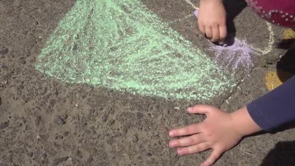 Baby hand tekenen met gekleurde krijtjes op de stoep — Stockvideo