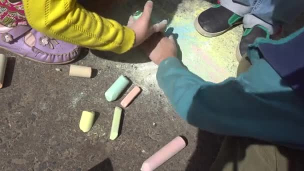 Baby hand drawing with colored chalks on the pavement — Stock Video
