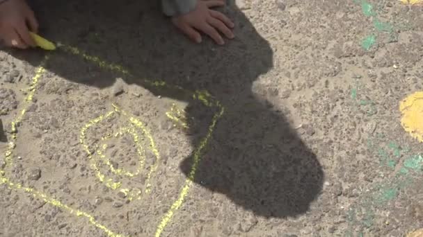 Baby-Handzeichnung mit farbigen Kreiden auf dem Bürgersteig — Stockvideo