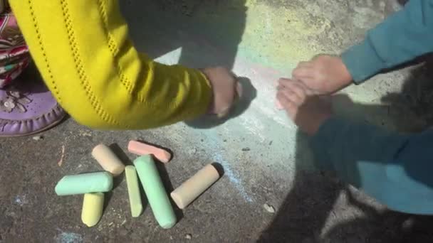 Baby-Handzeichnung mit farbigen Kreiden auf dem Bürgersteig — Stockvideo
