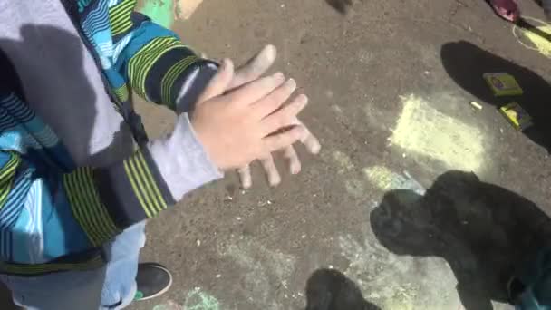 Малюнок дитячої руки з кольоровими чашами на тротуарі — стокове відео