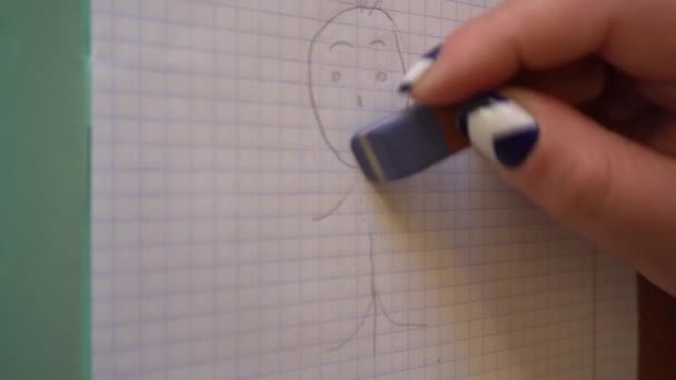 Womans ręka wymazuje mały człowiek w gumkę notebook — Wideo stockowe