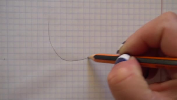 Mão de mulheres desenha um rosto sorridente com um lápis em um caderno — Vídeo de Stock