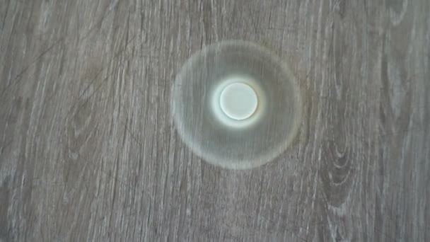 White hand spinner, or fidgeting spinner, rotating on the floor — Stock Video