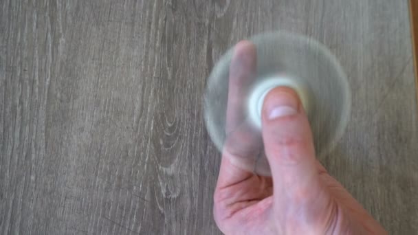 Weißer Handspinner oder zappelnder Spinner, der sich auf seiner Hand dreht — Stockvideo