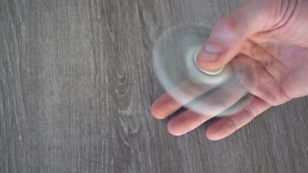 Weißer Handspinner oder zappelnder Spinner, der sich auf seiner Hand dreht — Stockvideo