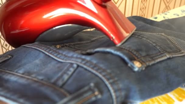 Mann dampft Jeansstoff auf Bügeltisch — Stockvideo