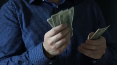 Genç iş adamı 100 dolar sayıyor.