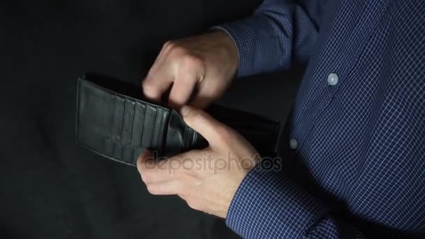 De man scharrelt in de portemonnee, en trekt vervolgens zijn honderd dollar bill — Stockvideo