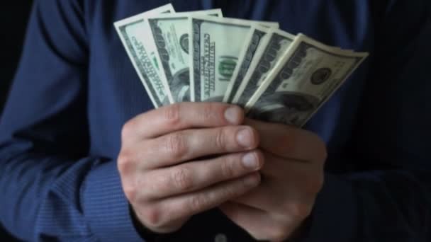Joven empresario sosteniendo un fan de billetes de cien dólares — Vídeos de Stock