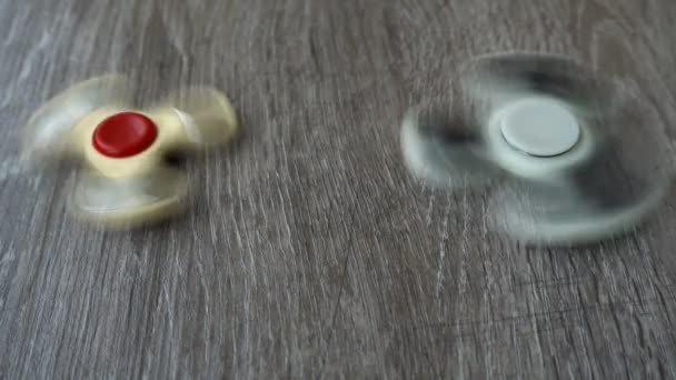 Dos spinner mano blanca girando sobre fondo gris o fidget spinners — Vídeos de Stock