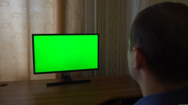 Mannenhand met Tv afstandsbediening schakelen kanalen op een groen scherm Tv oogpunt — Stockvideo