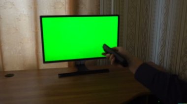 Erkek el ile Tv kanalları bakış bir yeşil ekran Tv nokta anahtarlama uzak