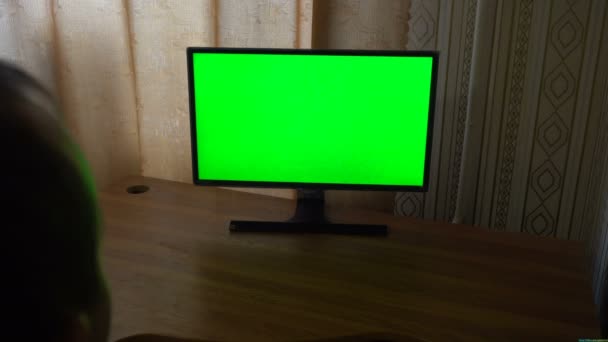 Αρσενική χέρι με τηλεκοντρόλ από μεταγωγή κανάλια σε μια πράσινη οθόνη Tv άποψη — Αρχείο Βίντεο