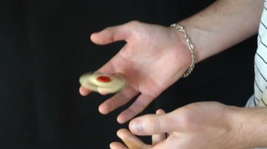 siyah bir zemin üzerine el spinner ile hüner, genç adam tek elle spinner diğer slowmotion atar