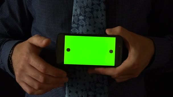 Uomo tiene smartphone alla fotocamera con schermo verde — Video Stock