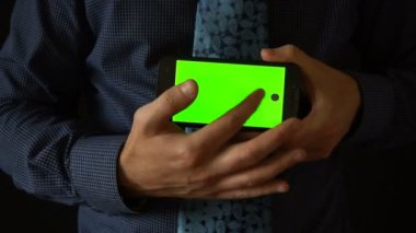 Adam için kamera ile yeşil perde smartphone tutar