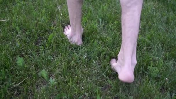 Les pieds d'homme courent dans l'herbe au ralenti — Video