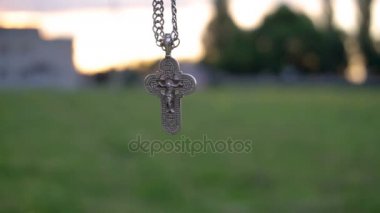 Bir zincir gündoğumu arka plan üzerinde Hristiyan çarmıhta