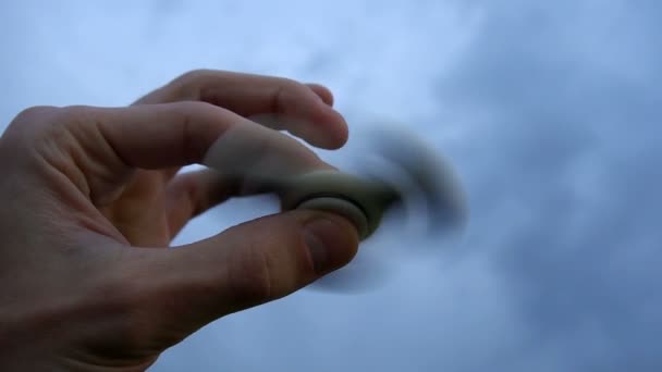 White hand spinner, or fidgeting spinner, rotating on childs hand — Stock Video