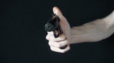 genç adam siyah silahla kameraya yönlendirir ve ateş etmeye çalışır