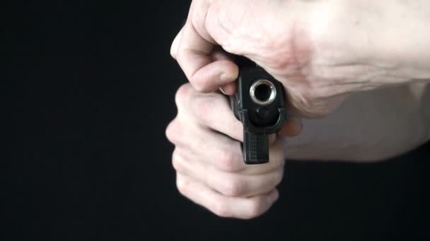 Молодий чоловік перезаряджає пістолет чорним — стокове відео