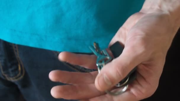 De jonge man zet de sleutels in je zak — Stockvideo