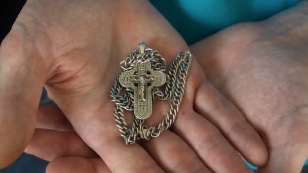 Der junge Kerl reicht ein christliches Kreuz und betet zu Gott im Himmel. täglicher traditioneller christlicher frommer junger Mann — Stockvideo