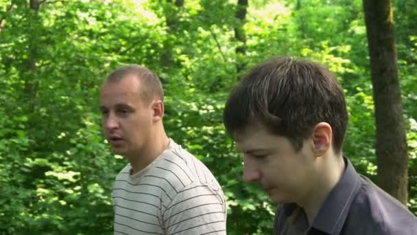 Two young men go through the woods and talking — Stock Video