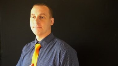 Genç iş adamı turuncu kravatını düzeltir ve evdeki aynaya bakar.