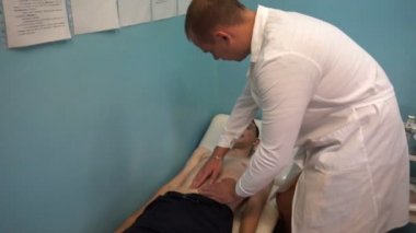 Terapistin resepsiyonunda, doktor hastaların karnını hisseder.