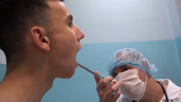 De jongeman op de receptie bij de tandarts. Tandheelkundige behandeling — Stockvideo