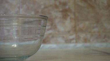 Yemek yemek. Taze organik yumurta kasenin içine düşüyor. Gıda içerikler. Cam kasede düşen yumurta sarısı. Fırın malzemeleri, sarısı protein ayıran. Malzemeler kek pişirme için hazırlanıyor