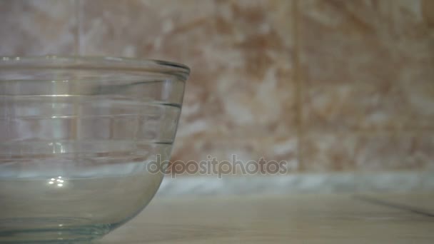 Cuisiner de la nourriture. Œufs biologiques frais tombant dans un bol. L'ingrédient alimentaire. Jaune d'oeuf tombant dans un bol en verre. Ingrédients de cuisson, séparant le jaune de la protéine. Préparation des ingrédients pour la cuisson du gâteau 