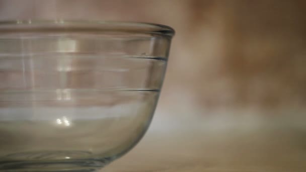 Cuisiner de la nourriture. Œufs biologiques frais tombant dans un bol. L'ingrédient alimentaire. Jaune d'oeuf tombant dans un bol en verre. Ingrédients de cuisson, séparant le jaune de la protéine. Préparation des ingrédients pour la cuisson du gâteau 