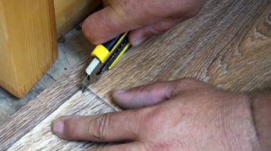 işçi muşamba bir yardımcı programı bıçakla keser linolyum katında uygun