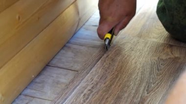 işçi muşamba bir yardımcı programı bıçakla keser linolyum katında uygun