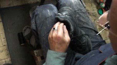 İşyerindeki ayakkabıcı. Atölyedeki ayakkabıları tamir etme süreci.