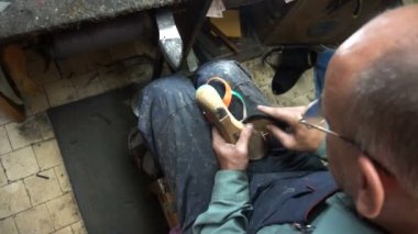 İşyerindeki ayakkabıcı. Atölyedeki ayakkabıları tamir etme süreci.