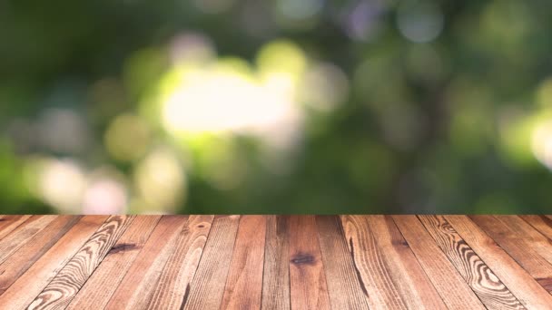 Perspektive Holz und Bokeh Licht Hintergrund. Produktdisplay-Vorlage. Holz Tischplatte auf Unschärfe bewegen natürliche grüne Blatt Hintergrund — Stockvideo