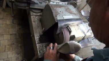 Ayakkabı tamircisi makinenin musluklarını biler