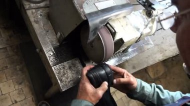 Ayakkabı tamircisi makinenin musluklarını biler