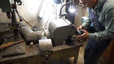 Ayakkabı tamircisi makinenin musluklarını biler