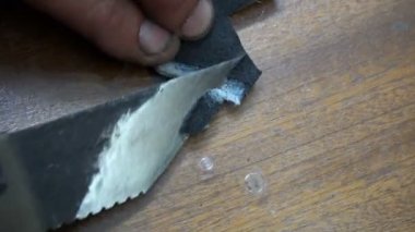 bir kunduracı bir özel bıçak siyah deri yama temizler