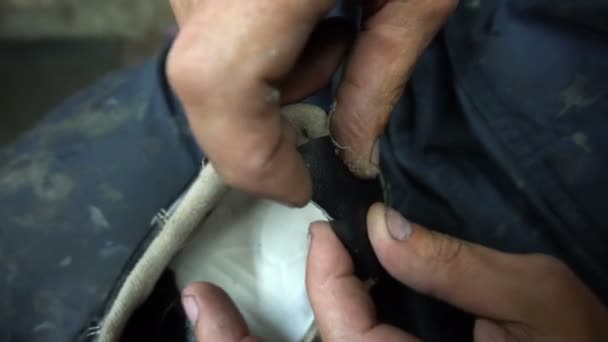 El zapatero pega un parche de cuero negro en las zapatillas — Vídeos de Stock