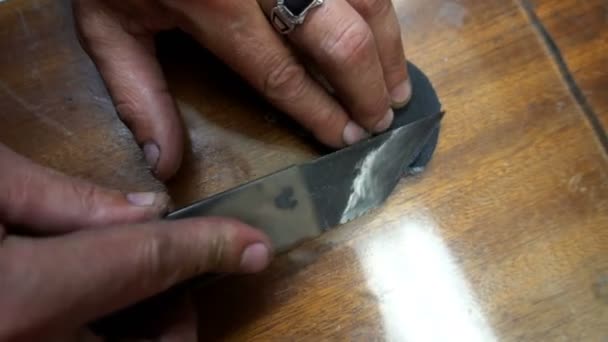 Un zapatero limpia un parche de cuero negro cuchillo especial — Vídeos de Stock