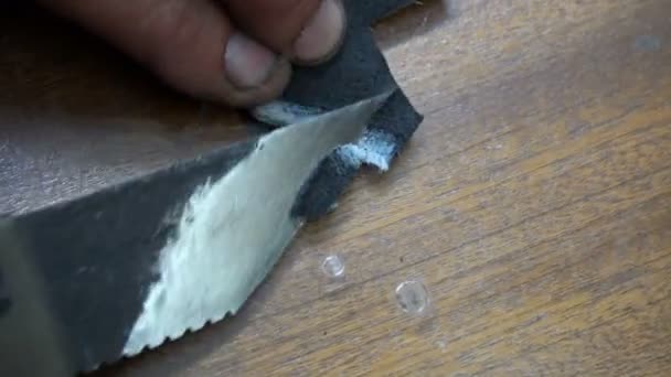 Een schoenmaker reinigt een speciale mes zwart lederen patch — Stockvideo
