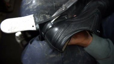 Shoemaker atölyede ayakkabıyı tamir ederken 4k ayakkabıların musluklarını kesti.