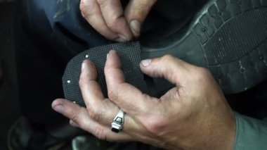 Shoemaker atölyede ayakkabıyı tamir ederken 4k topuk kapağını topuğa çiviler.