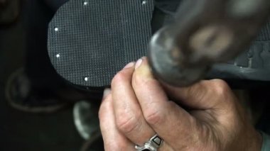Shoemaker atölyede ayakkabıyı tamir ederken 4k topuk kapağını topuğa çiviler.